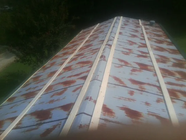 Rusted metal roof panels with new wood purlins before replacement in West Chesterfield