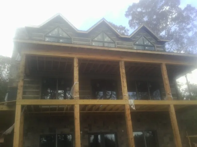 Dormers and porch framing on a large log home under construction — Roof Coating work by our crew in West Chesterfield
